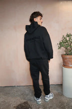 Fear of God Essentials Limo Black — hoodie noir profond porté